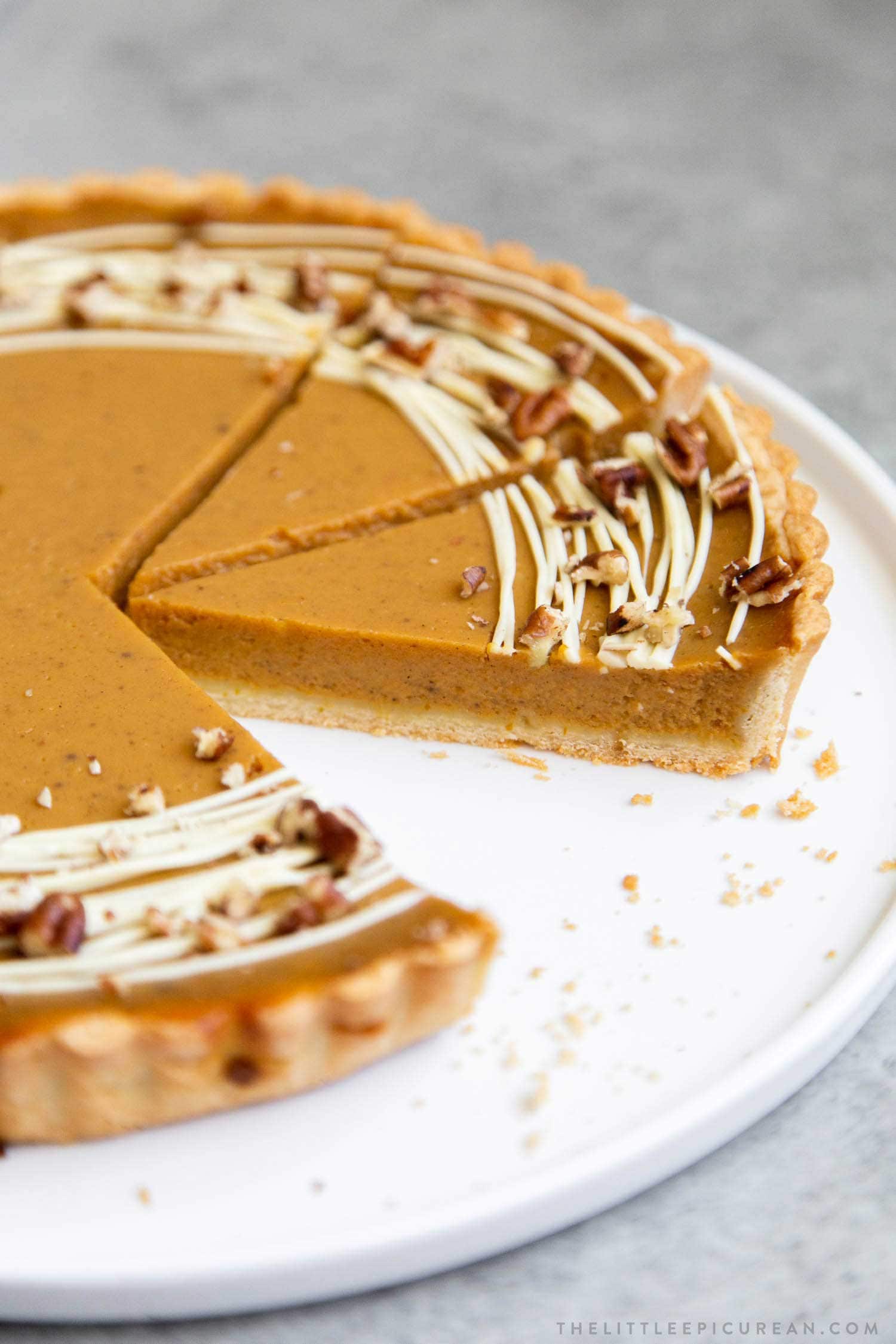 Easy Pumpkin Tart. Tart shell is made with a buttery shortbread crust. The one bowl pumpkin filling is a breeze to a make. It's decorated with melted white chocolate and chopped pecans. #pumpkin #pumpkintart #piesandtarts #dessert #thanksgiving