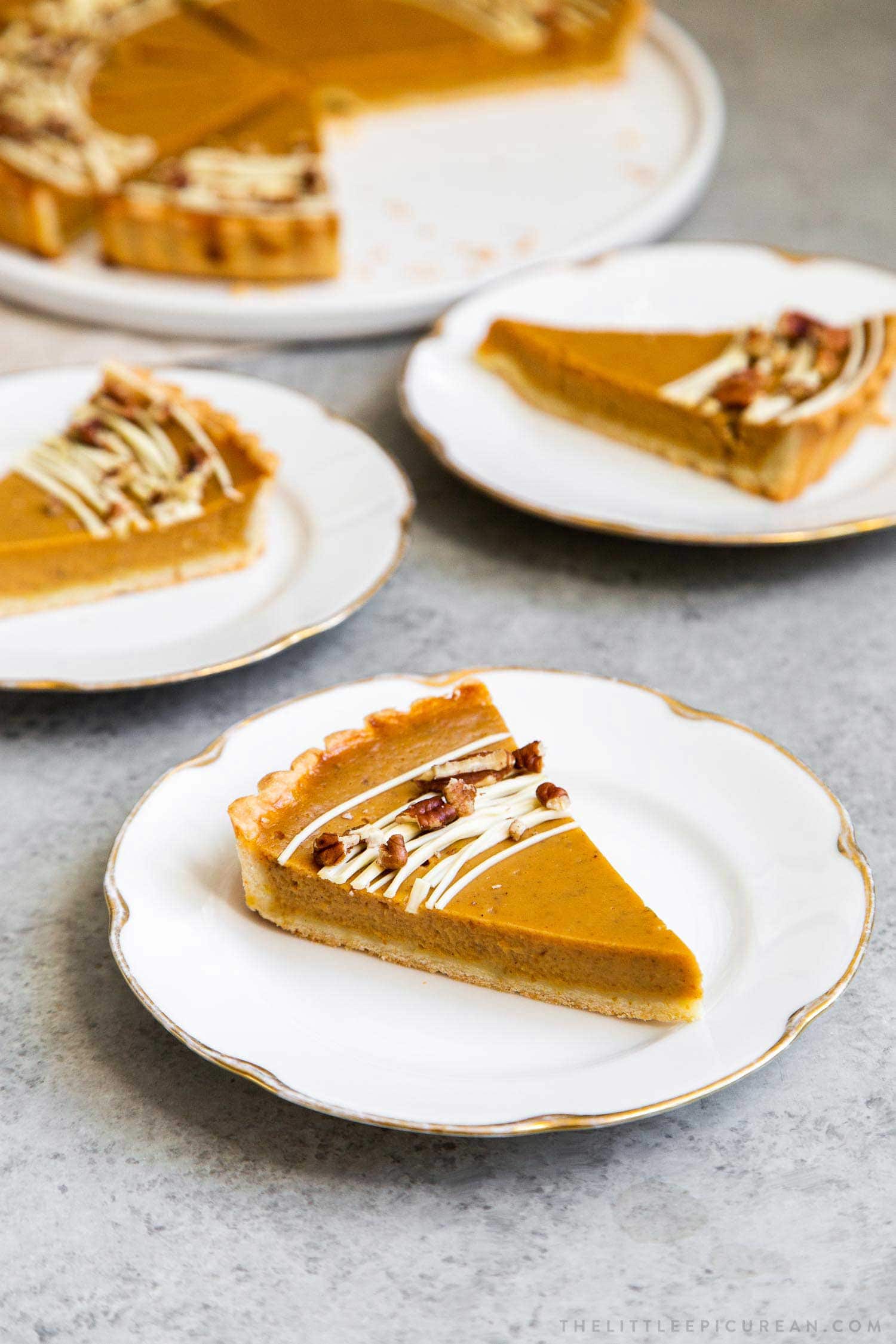 Easy Pumpkin Tart. Tart shell is made with a buttery shortbread crust. The one bowl pumpkin filling is a breeze to a make. It's decorated with melted white chocolate and chopped pecans. #pumpkin #pumpkintart #piesandtarts #dessert #thanksgiving