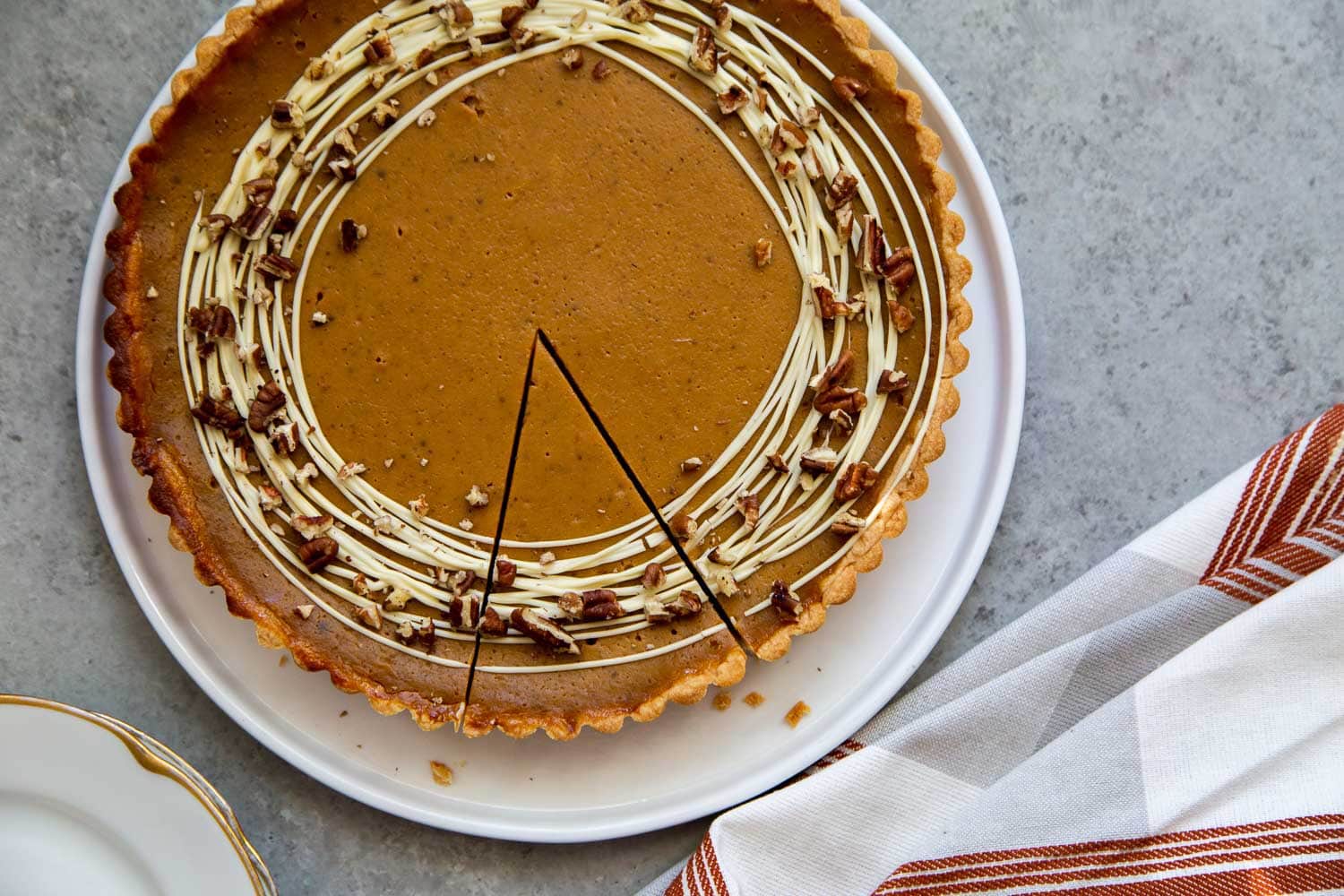 Easy Pumpkin Tart. Tart shell is made with a buttery shortbread crust. The one bowl pumpkin filling is a breeze to a make. It's decorated with melted white chocolate and chopped pecans. #pumpkin #pumpkintart #piesandtarts #dessert #thanksgiving