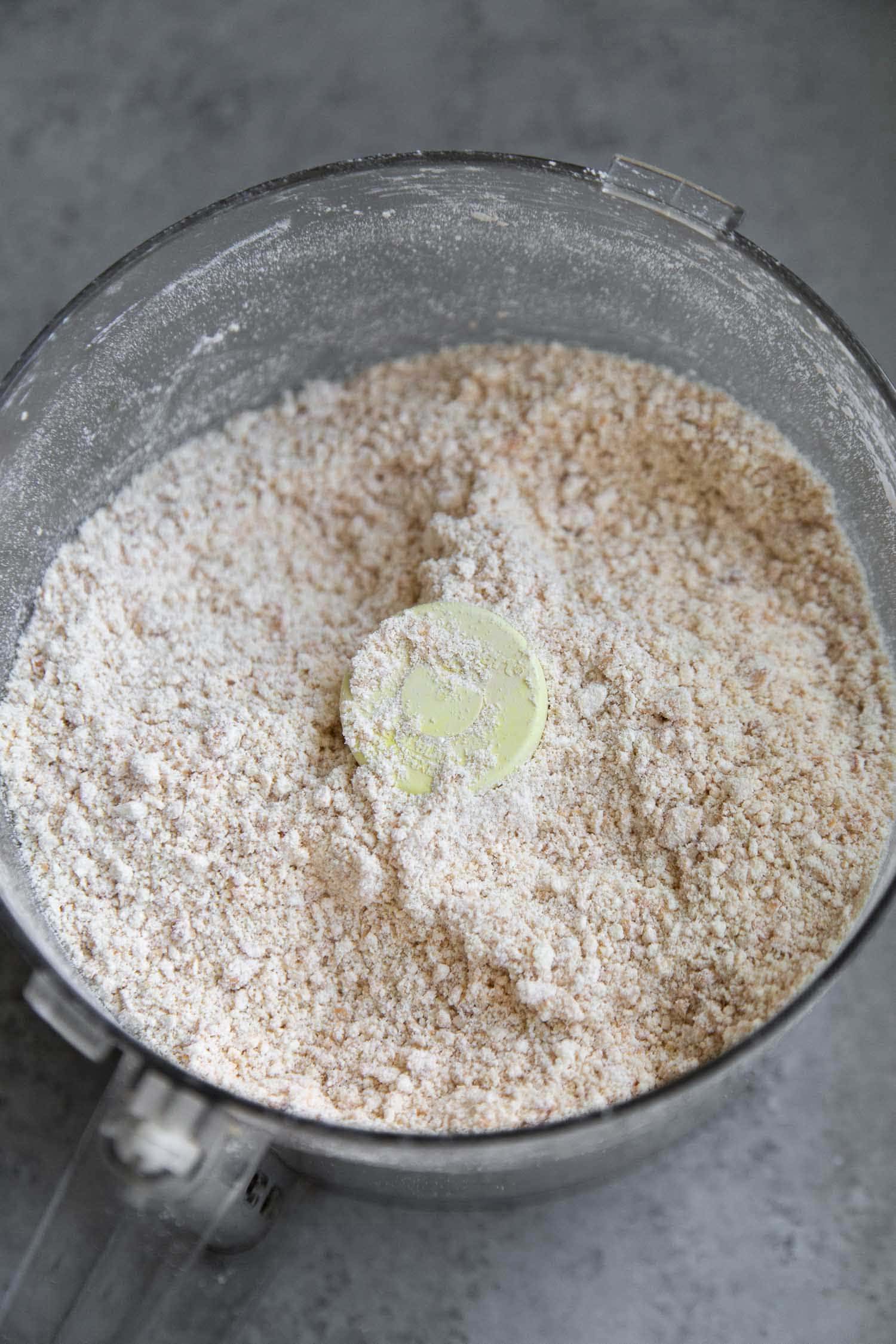 Process roasted cashews and powdered sugar until cashews are evenly ground. 