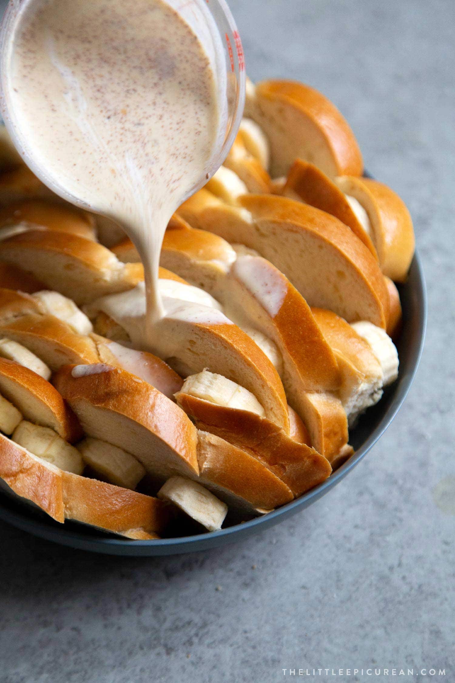 Banana Foster Bread Pudding. Sliced challah bread soaked in spiced custard mixture, baked until golden, and topped with brown sugar cooked bananas and caramel sauce. #breakfast #brunch #breadpudding #dessert #sweet