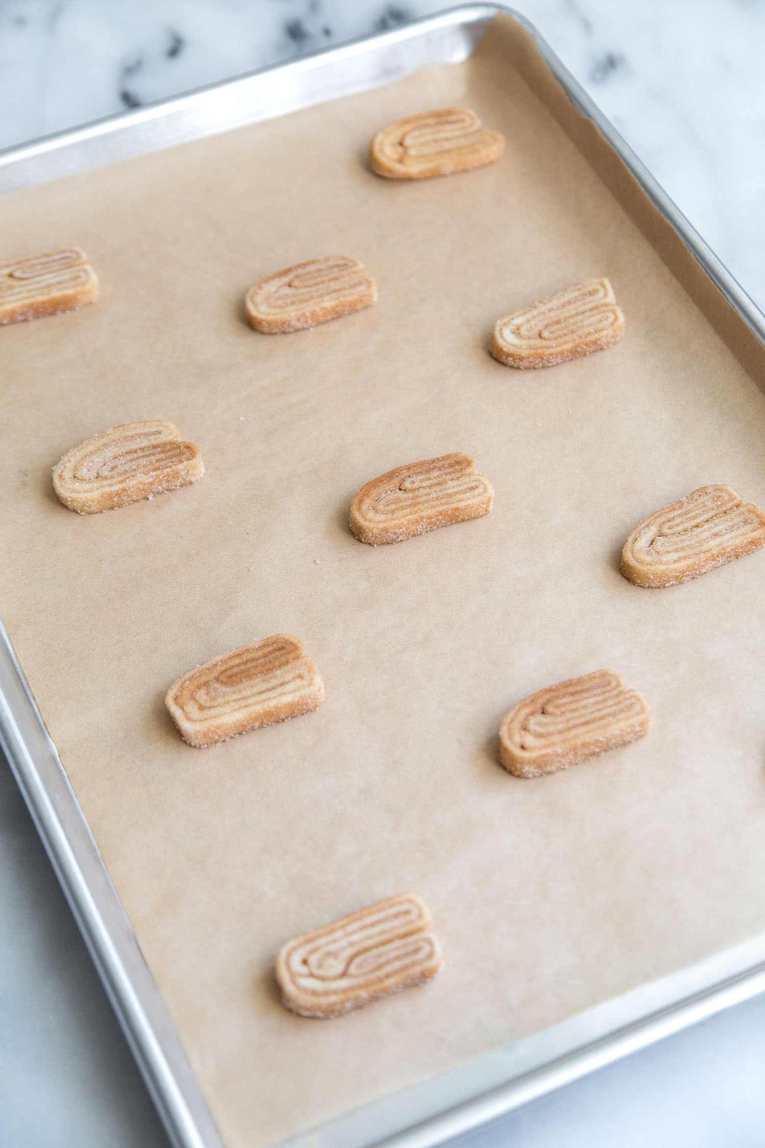 Cinnamon Sugar Palmiers. Space the frozen cookie portions on a parchment lined baking sheets. Palmiers will spread out during baking. #palmiers #cinnamonsugar #cookies #dessert