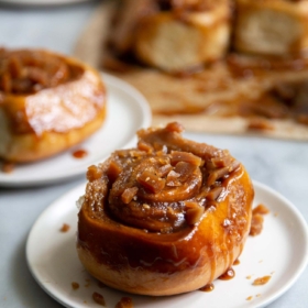 Toffee Sticky Buns. These warm and fluffy buns are filled with cinnamon sugar, coated with a sweet molasses glaze, and topped with chopped toffee bits! #breakfast #brunch #holidays #toffee #stickybuns