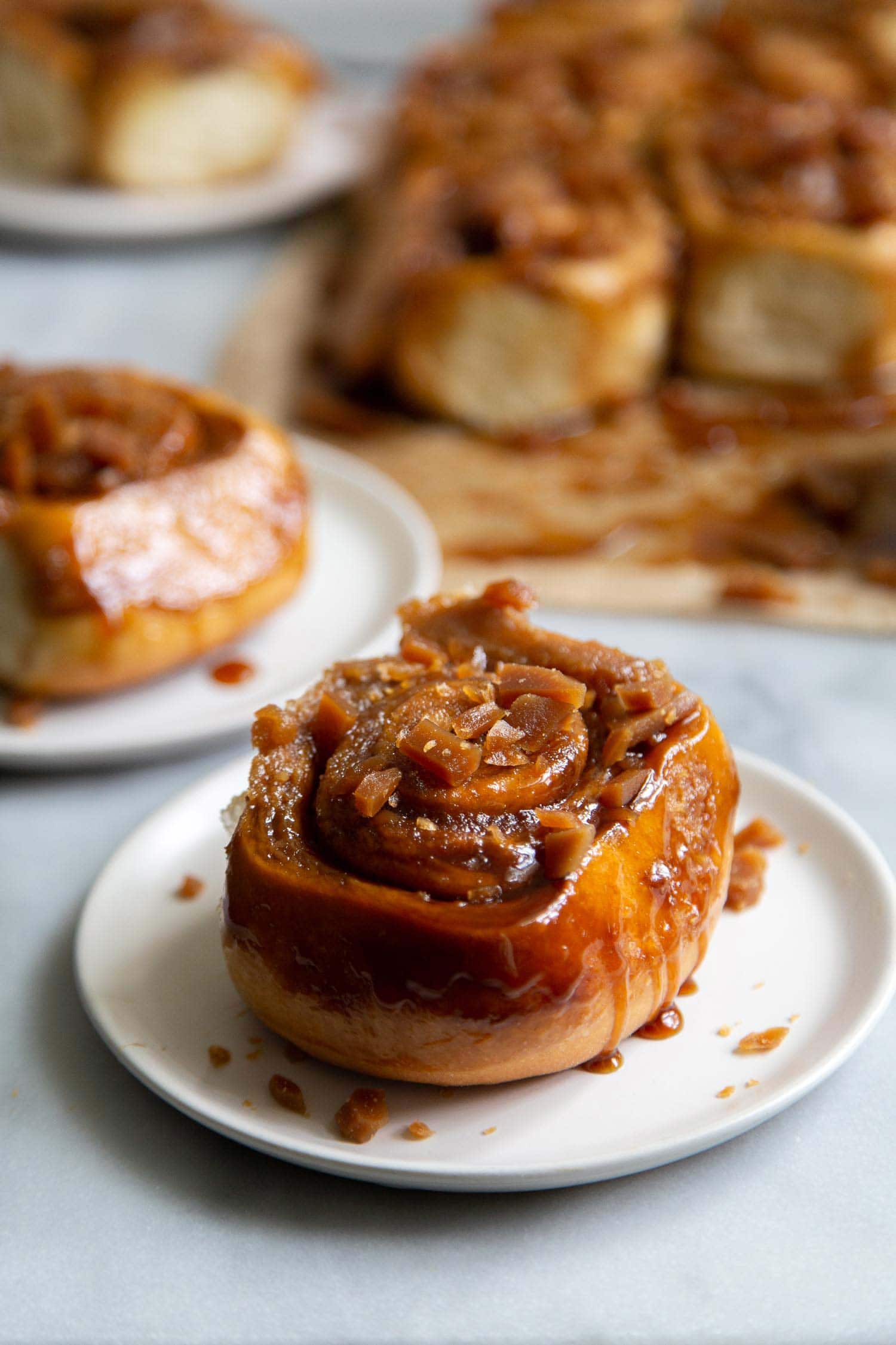 Toffee Sticky Buns. These warm and fluffy buns are filled with cinnamon sugar, coated with a sweet molasses glaze, and topped with chopped toffee bits! #breakfast #brunch #holidays #toffee #stickybuns