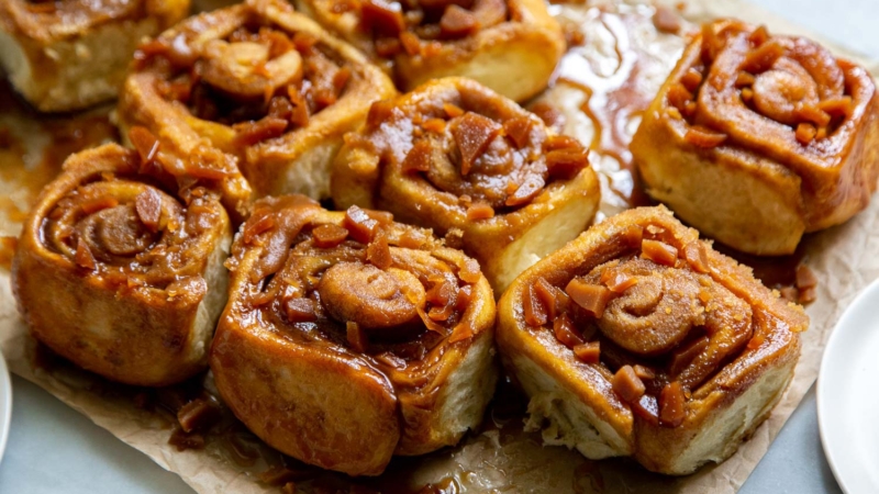 Toffee Sticky Buns. These warm and fluffy buns are filled with cinnamon sugar, coated with a sweet molasses glaze, and topped with chopped toffee bits! #breakfast #brunch #holidays #toffee #stickybuns