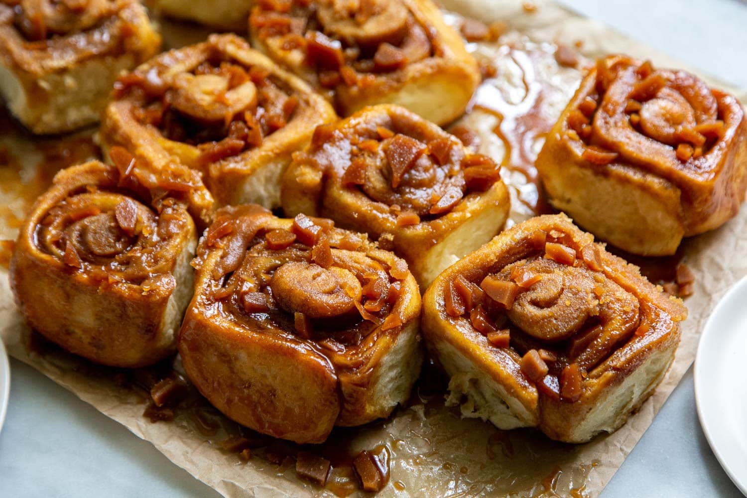 Toffee Sticky Buns. These warm and fluffy buns are filled with cinnamon sugar, coated with a sweet molasses glaze, and topped with chopped toffee bits! #breakfast #brunch #holidays #toffee #stickybuns