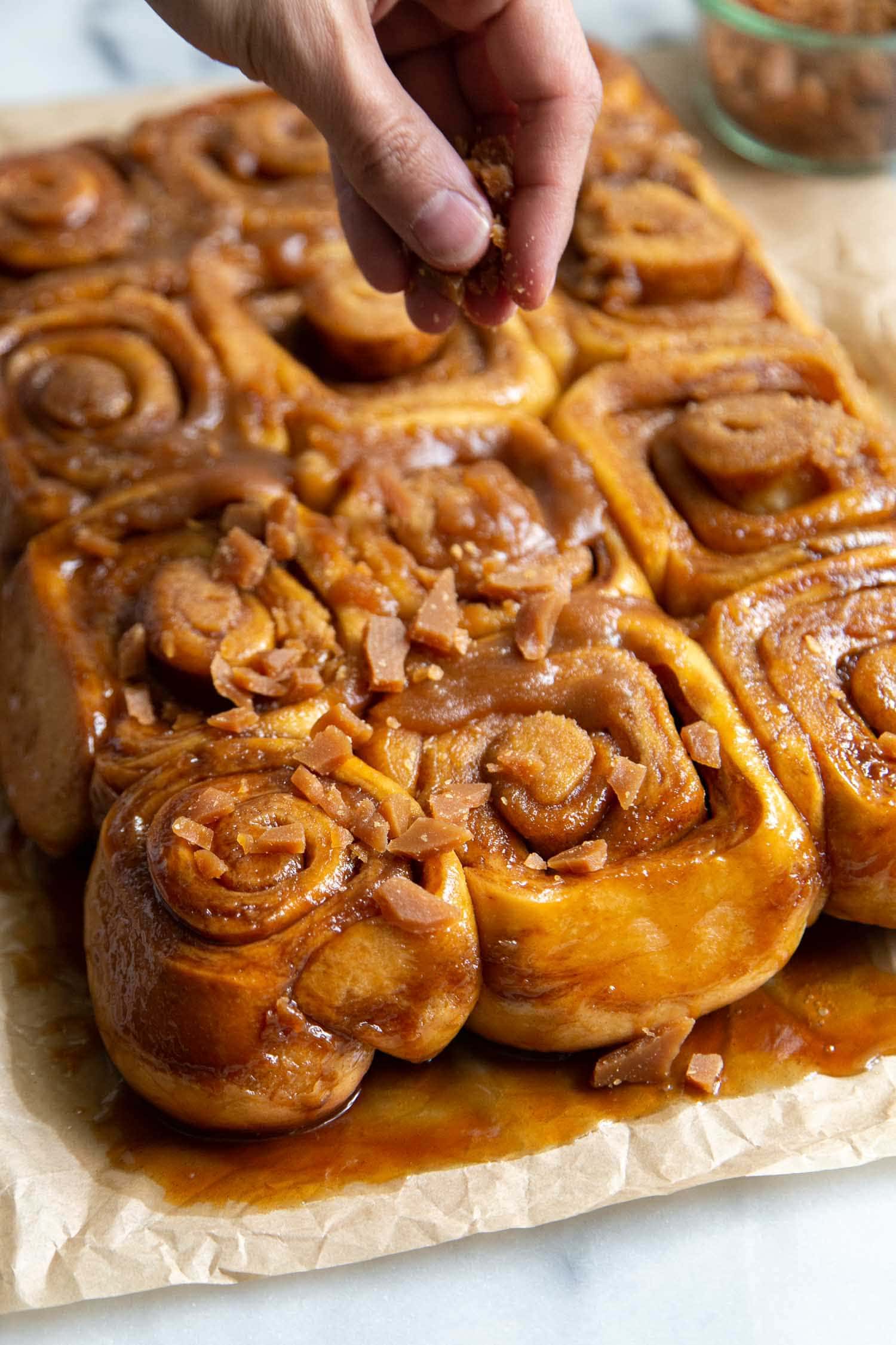 Toffee Sticky Buns. These warm and fluffy buns are filled with cinnamon sugar, coated with a sweet molasses glaze, and topped with chopped toffee bits! #breakfast #brunch #holidays #toffee #stickybuns