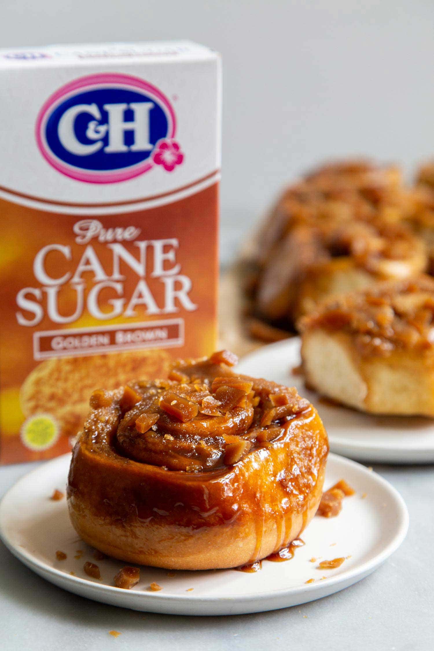 Toffee Sticky Buns. These warm and fluffy buns are filled with cinnamon sugar, coated with a sweet molasses glaze, and topped with chopped toffee bits! #breakfast #brunch #holidays #toffee #stickybuns