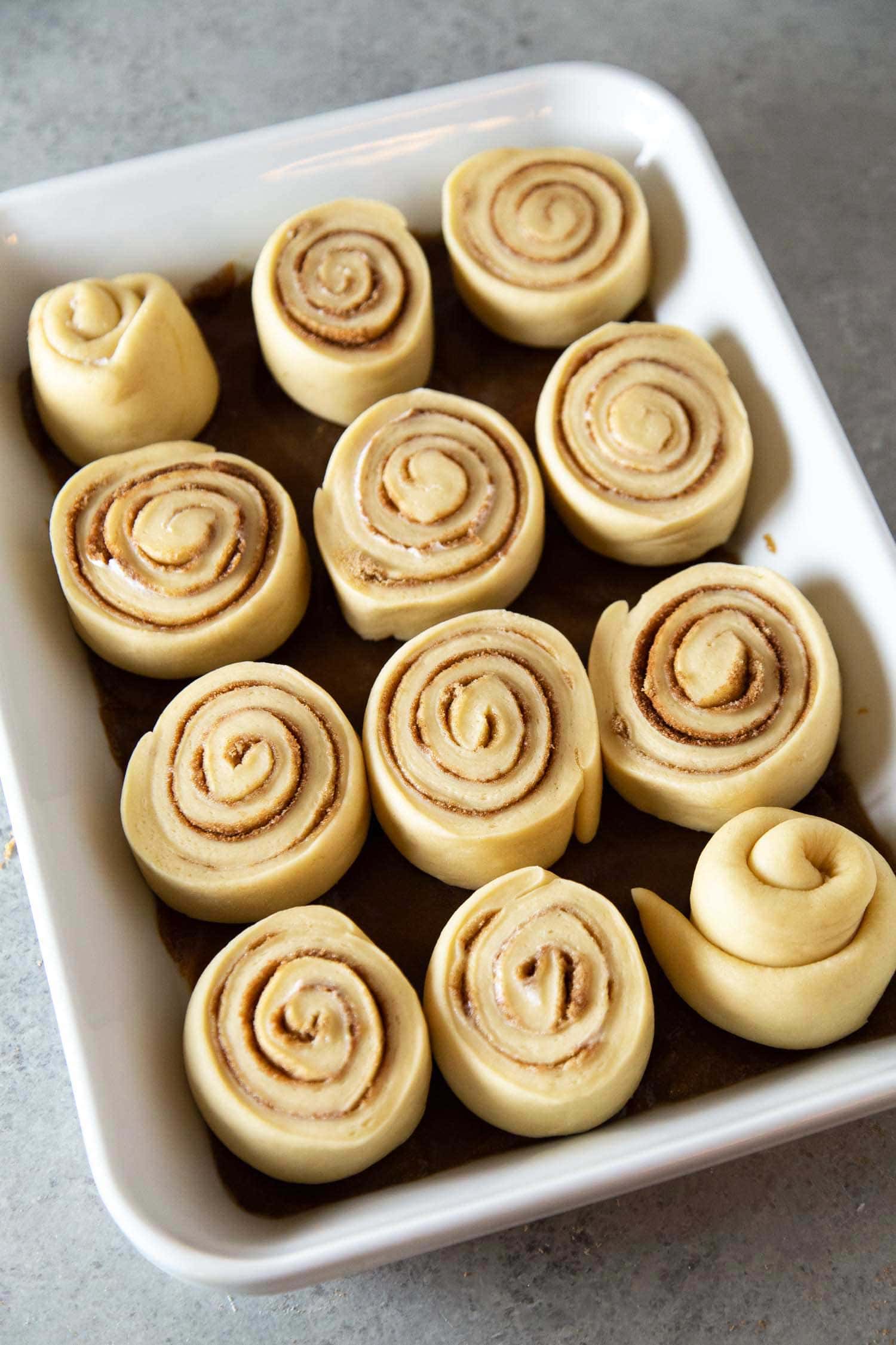 Toffee Sticky Buns. These warm and fluffy buns are filled with cinnamon sugar, coated with a sweet molasses glaze, and topped with chopped toffee bits! #breakfast #brunch #holidays #toffee #stickybuns