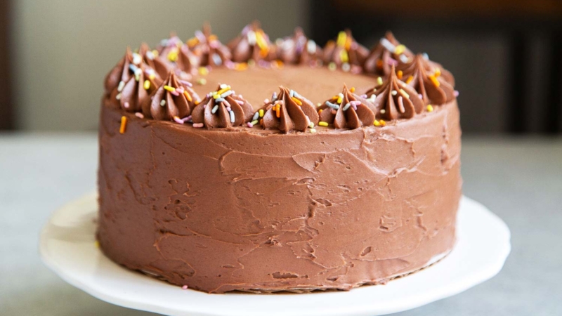 Classic Chocolate Cake. This recipe makes a two layer 8-inch cake or a three layer 6-inch cake. It is frosted with a simple chocolate American buttercream and decorated with rainbow sprinkles.