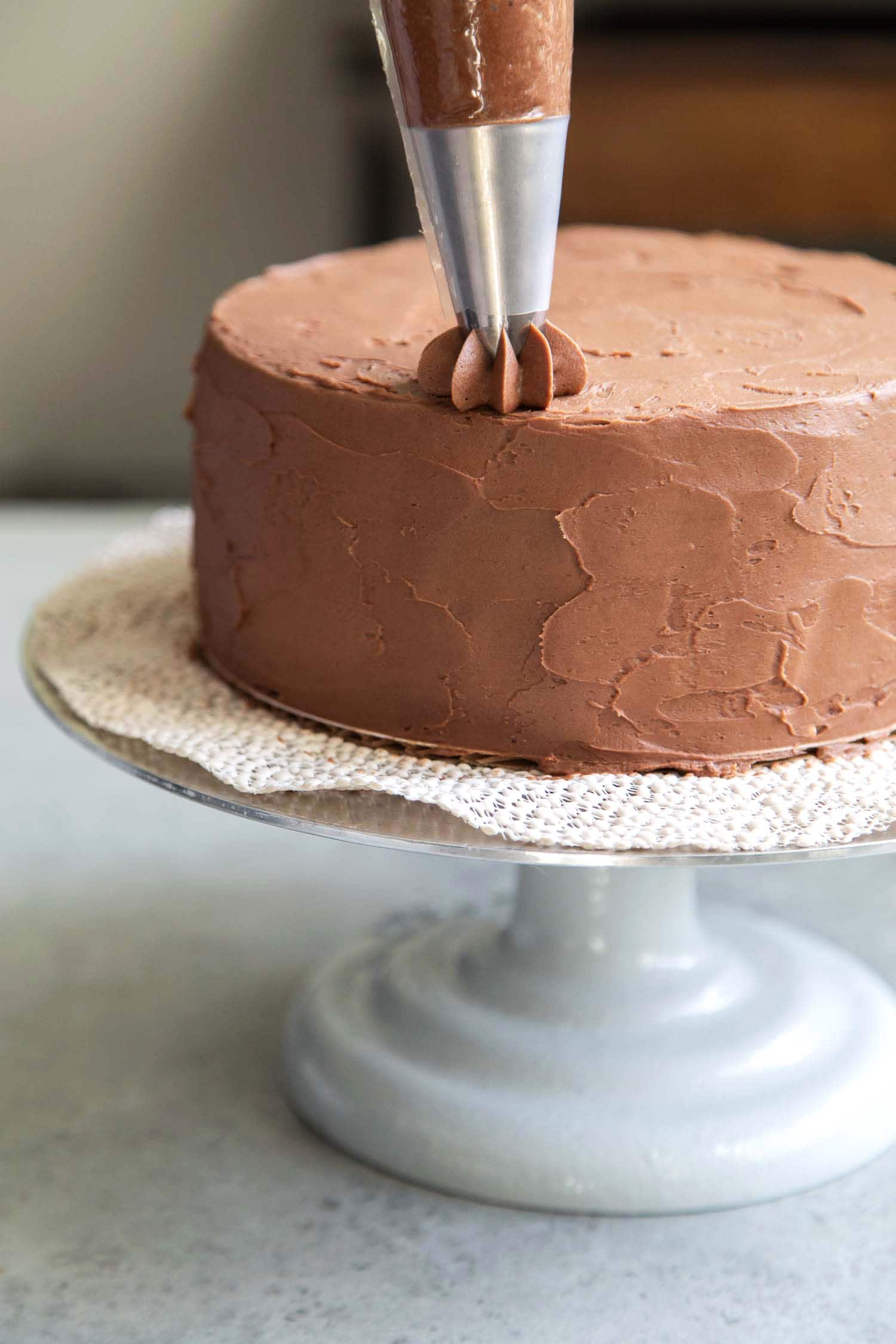 Use a star tip to decorate classic chocolate cake with buttercream.