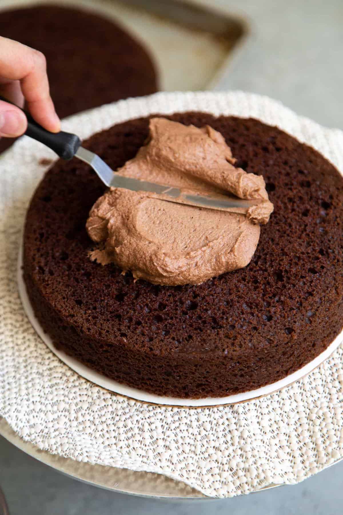 spread chocolate buttercream over chocolate cake layer.