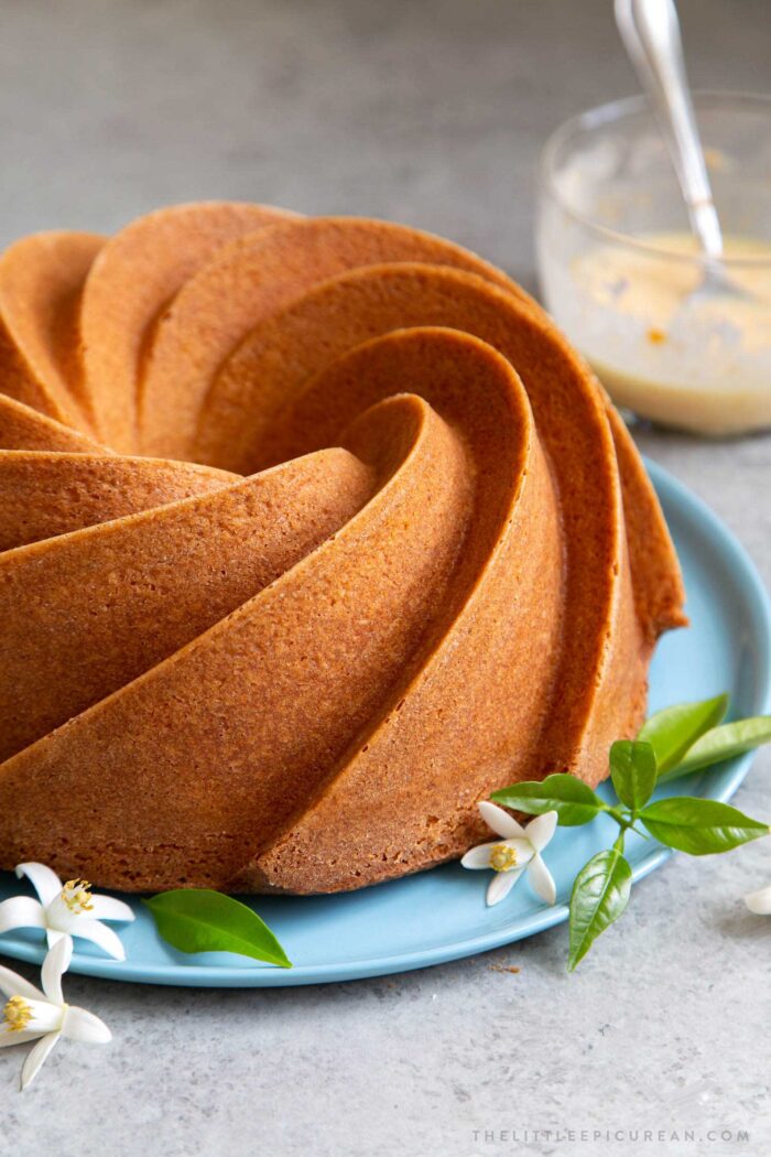 Orange blossom bundt cake on blue serving plate before glazing.