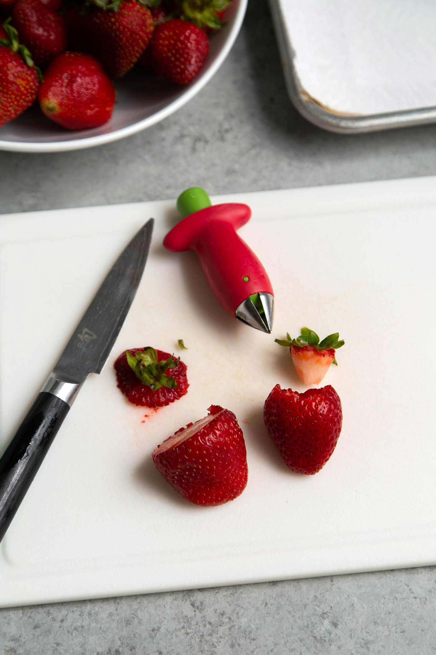 Use a strawberry huller or pairing knife to prepare strawberries for freezing