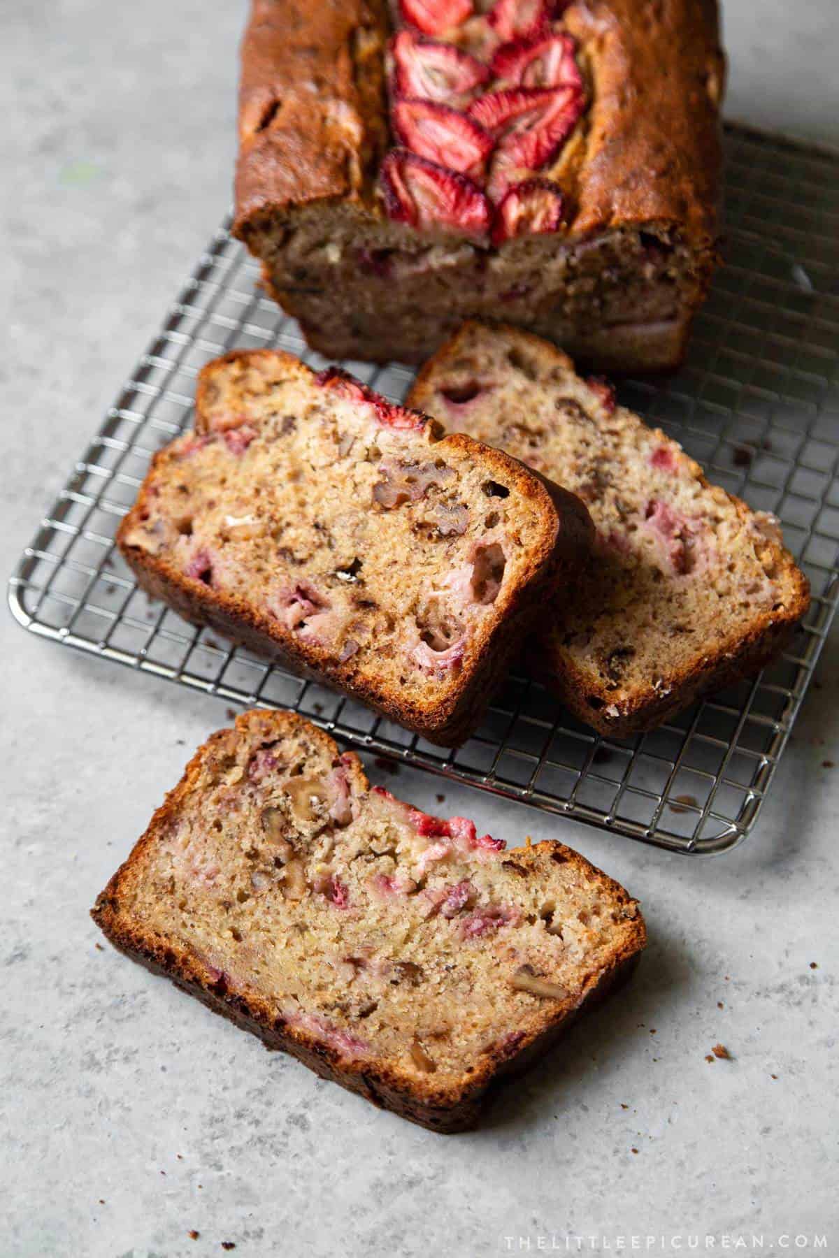 slices of strawberry banana bread on wire rack. 