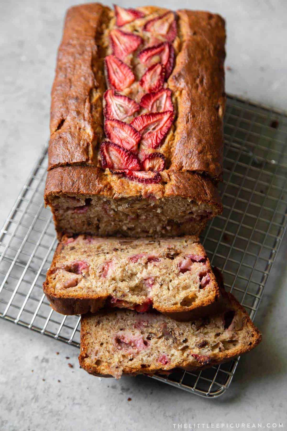 sliced strawberry banana bread on wire rack.