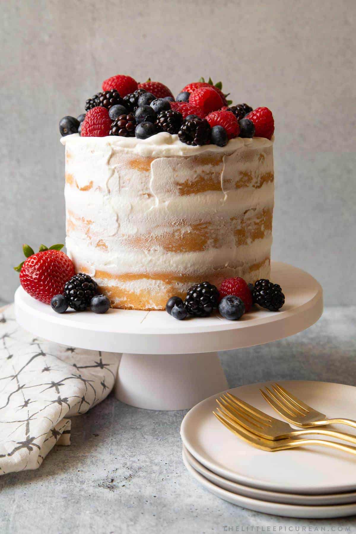 layered coconut cake with whipped cream frosting and fresh berries