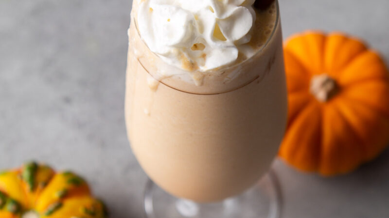 pumpkin milkshake topped with whipped cream and biscoff cookie