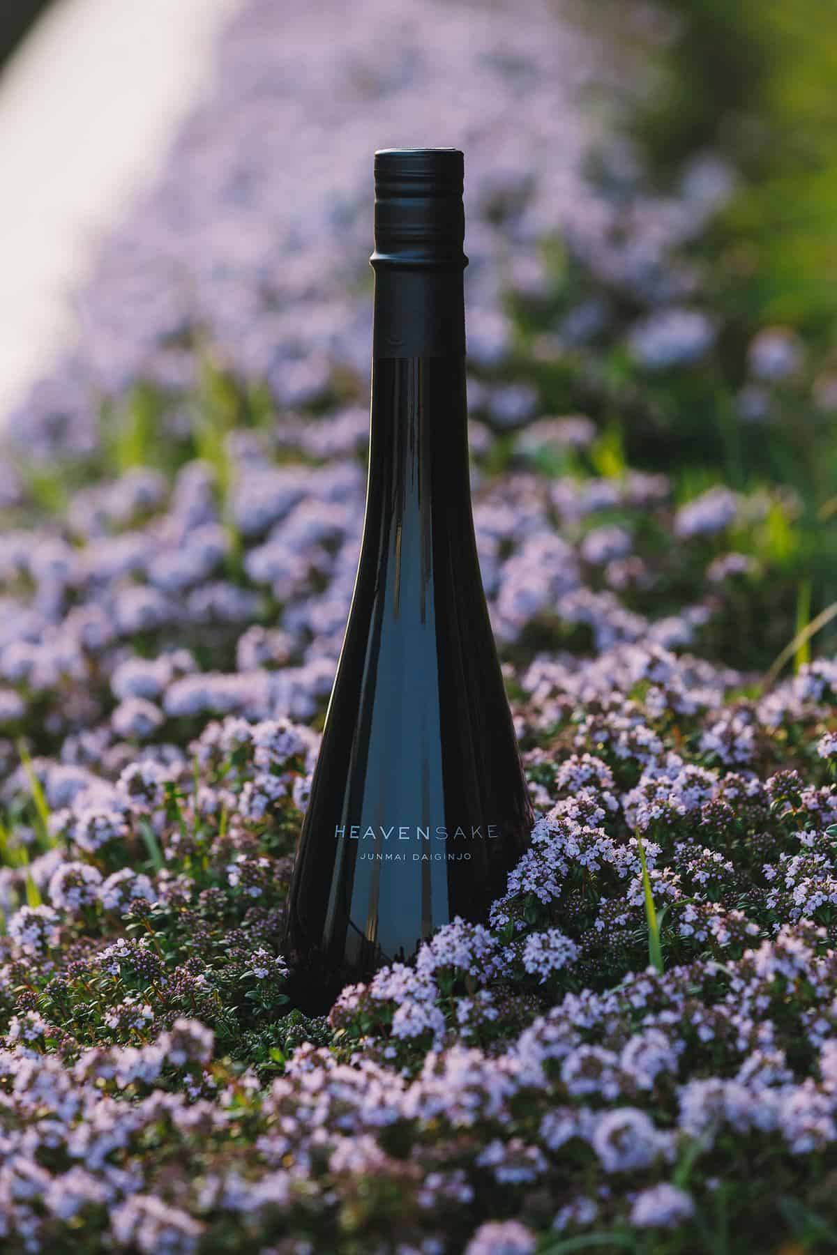 HeavenSake Junmai Daiginjo bottle in a field of purple flowers