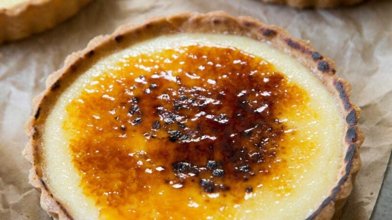 close up of creme brulee tart placed on top of unbleached parchment paper.