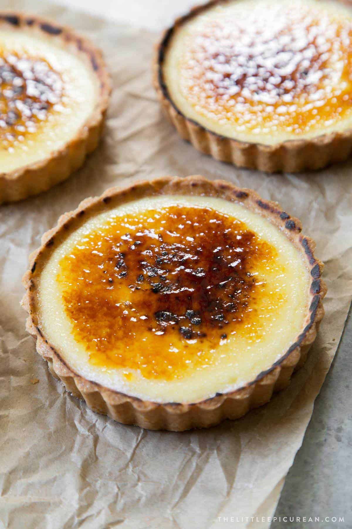 close up of creme brulee tart placed on top of unbleached parchment paper.