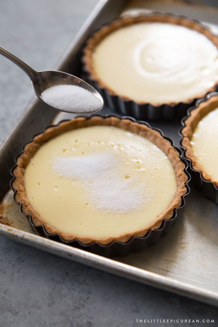 sprinkling granulated sugar over filled tart shell.