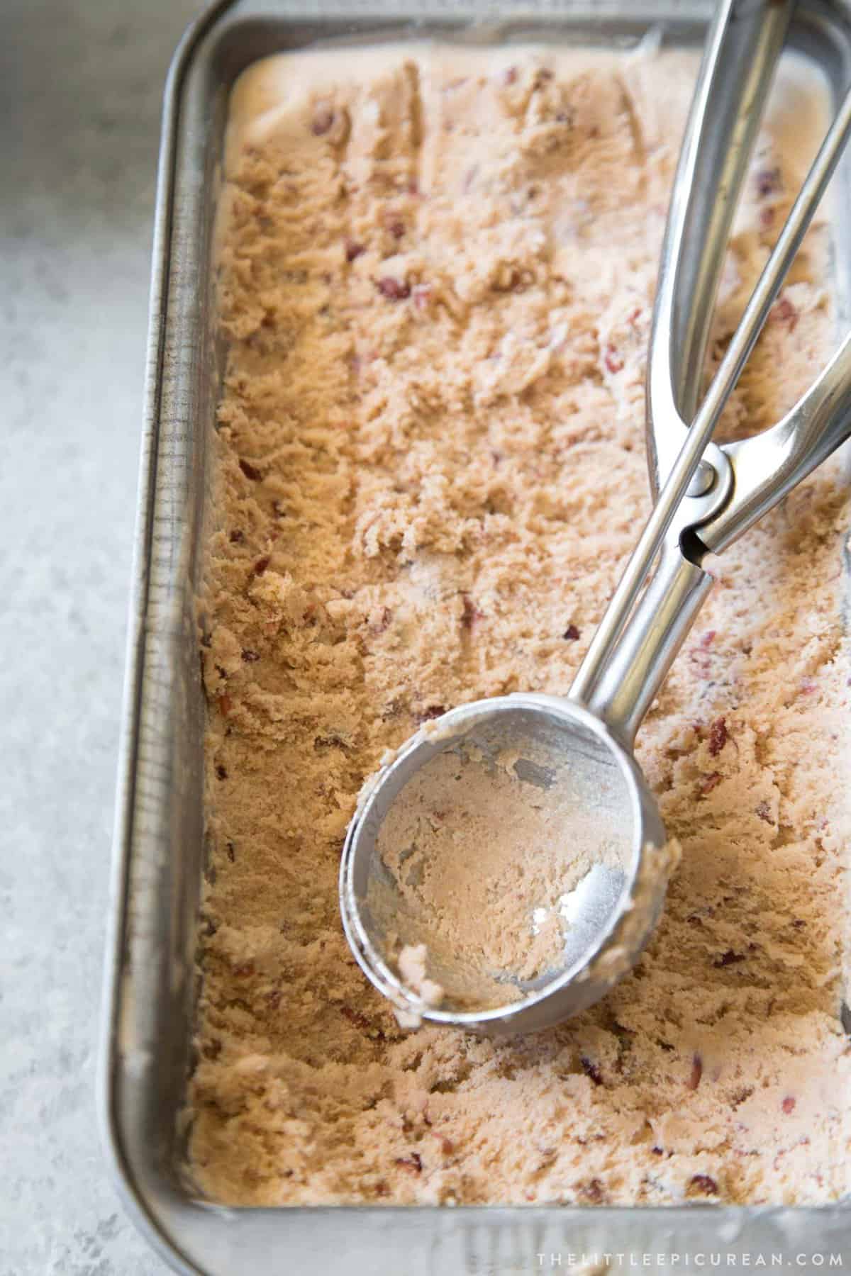 ice cream scooper on top of loaf pan filled with red bean ice cream.