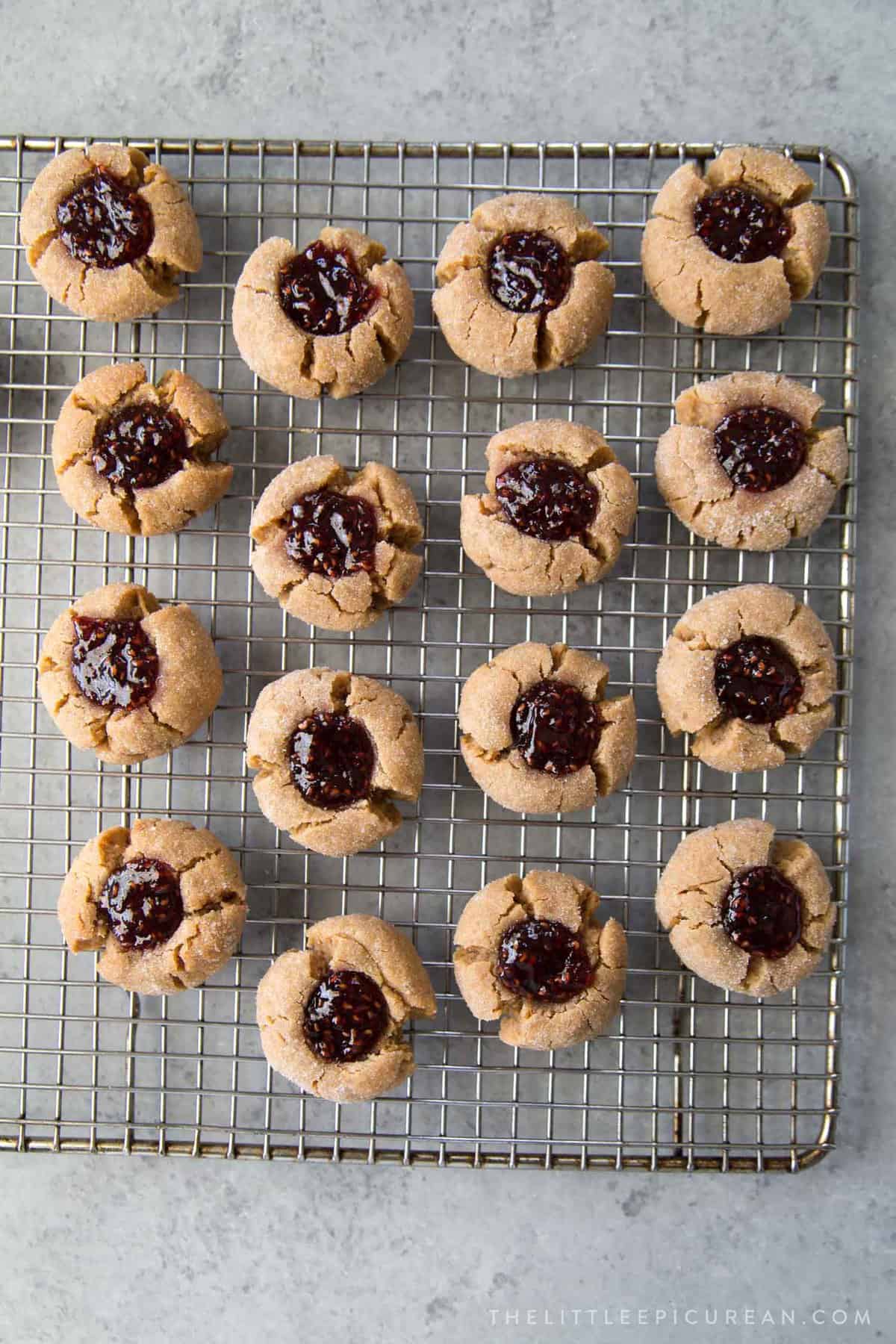 peanut butter jelly thumbprint cookies on wire rack.