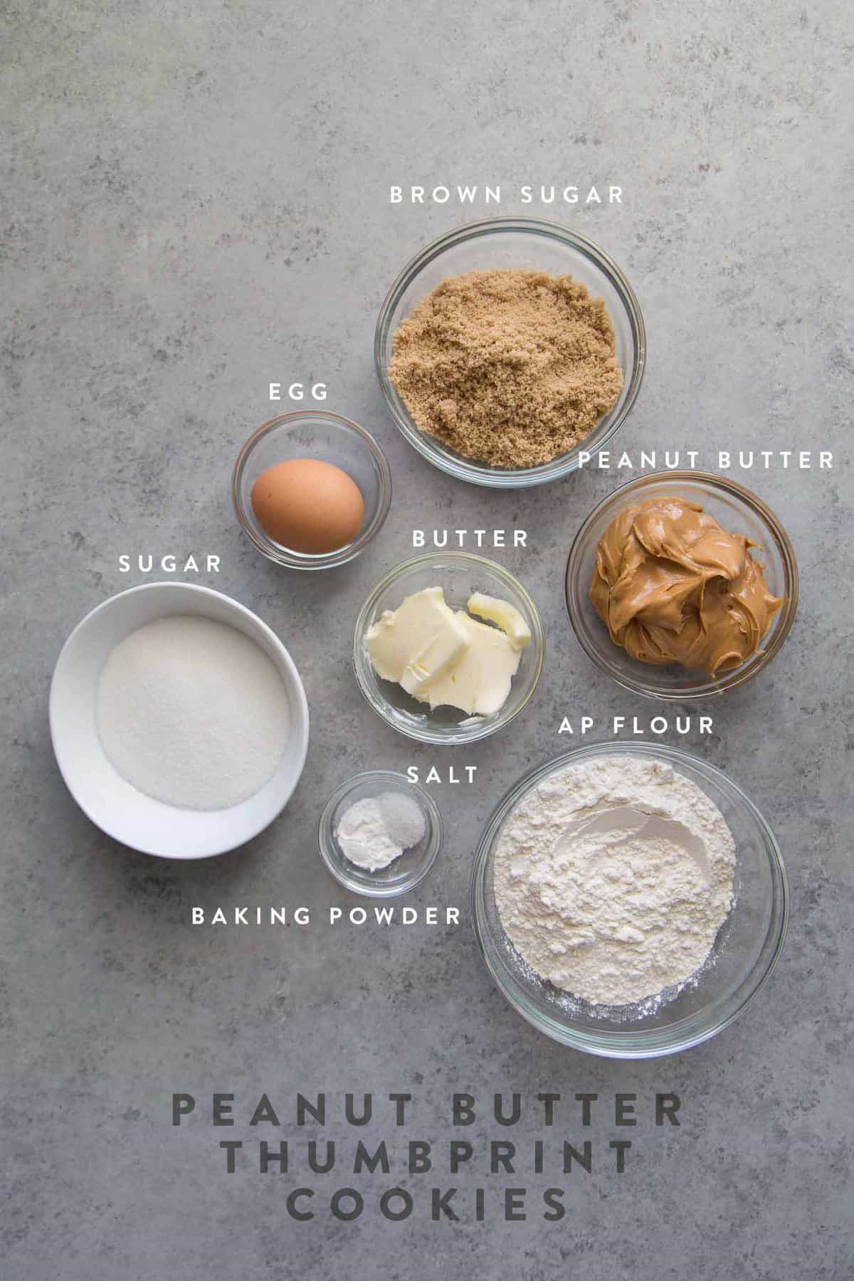 portioned ingredients in glass bowls to make peanut butter cookies.