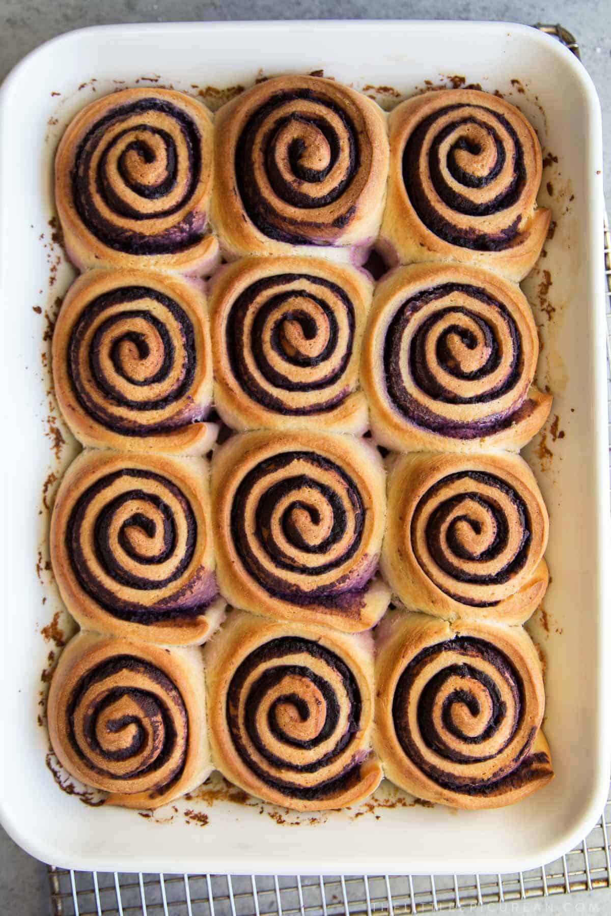 ube bread rolls in rectangle white baking dish.