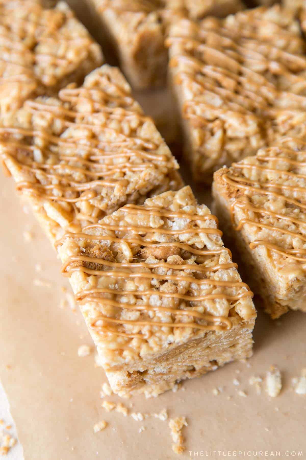 brown butter biscoff rice krispie treats topped with melted cookie butter drizzle.