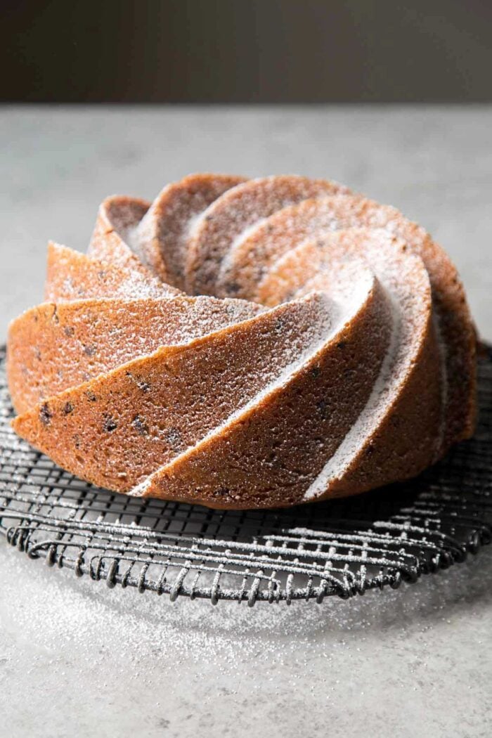 powdered sugar dusted chocolate chip bundt cake on wire rack.