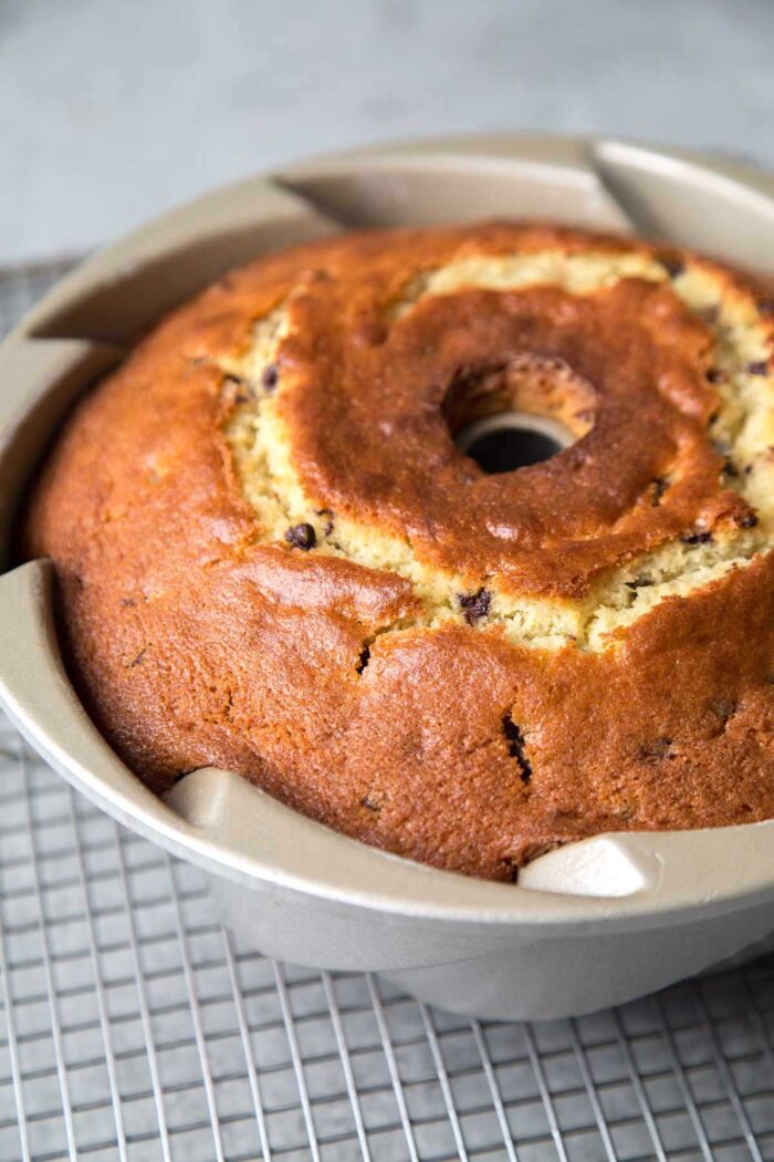 baked chocolate chip bundt cake in pan on wire rack.