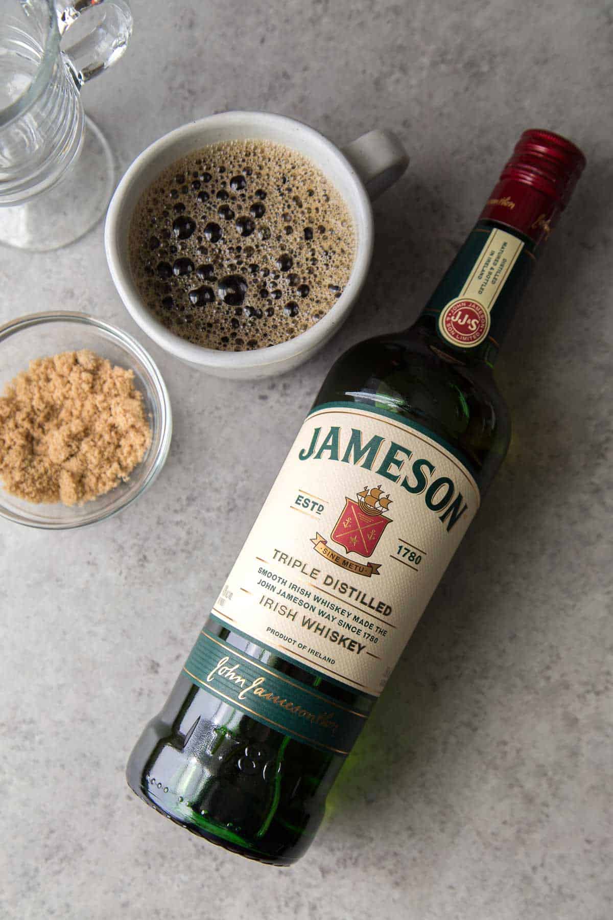Jameson Irish whiskey bottle with black coffee and brown sugar.