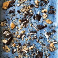close up of blue cookie monster ice cream studded with chopped cookies and oreos.