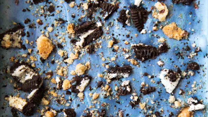 close up of blue cookie monster ice cream studded with chopped cookies and oreos.