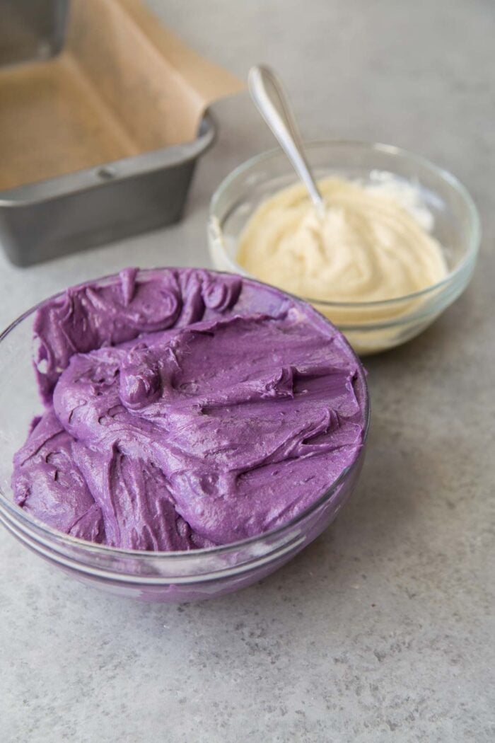 ube cake batter and vanilla cake batter in separate bowls. 