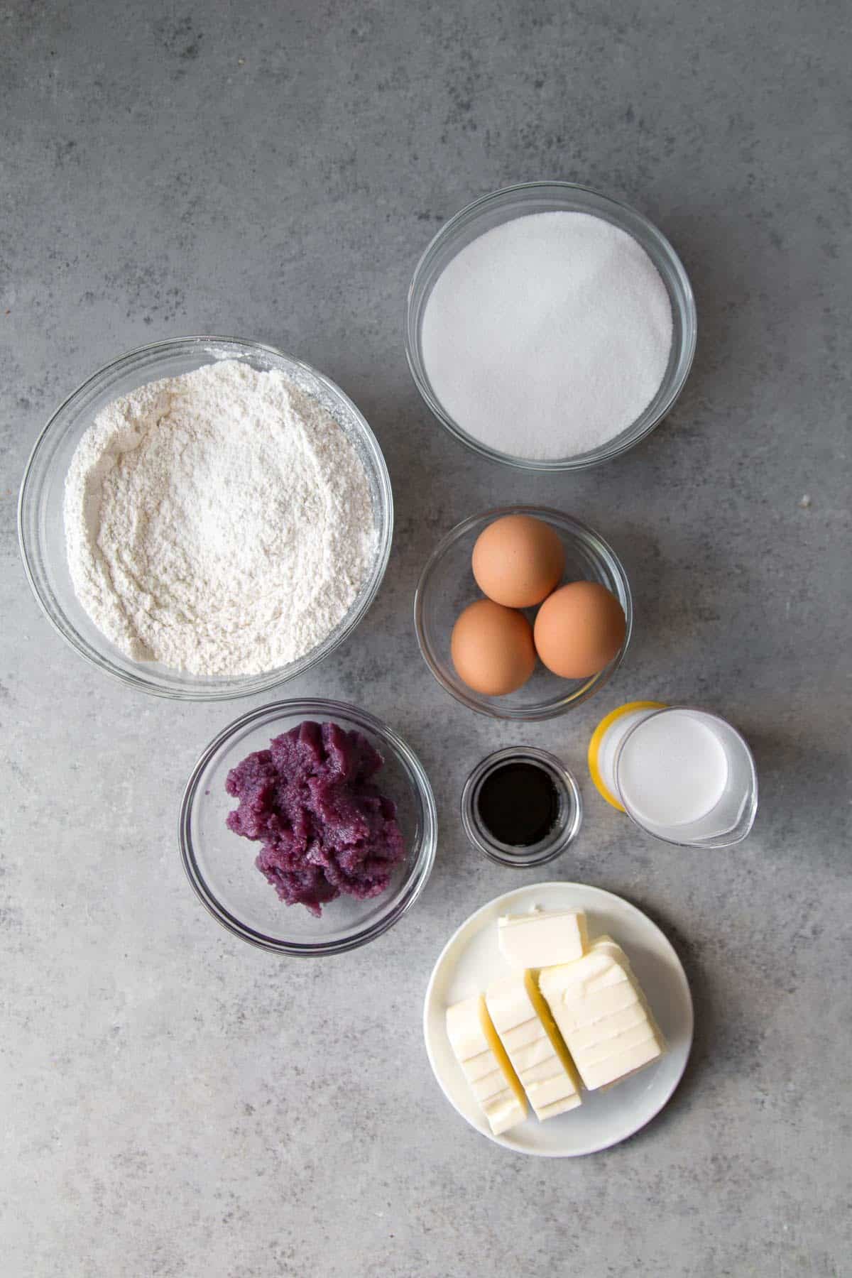 overhead of ingredients needed to make ube pound cake including butter, eggs, ube halaya.