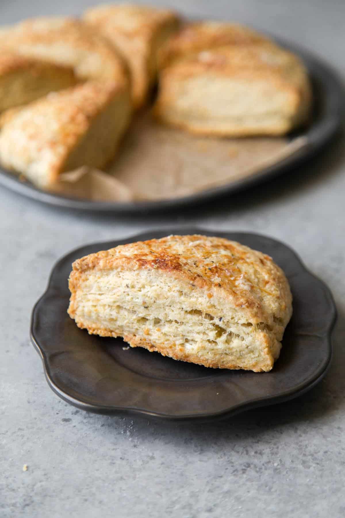 savory cheese scone wedge on dark plate.