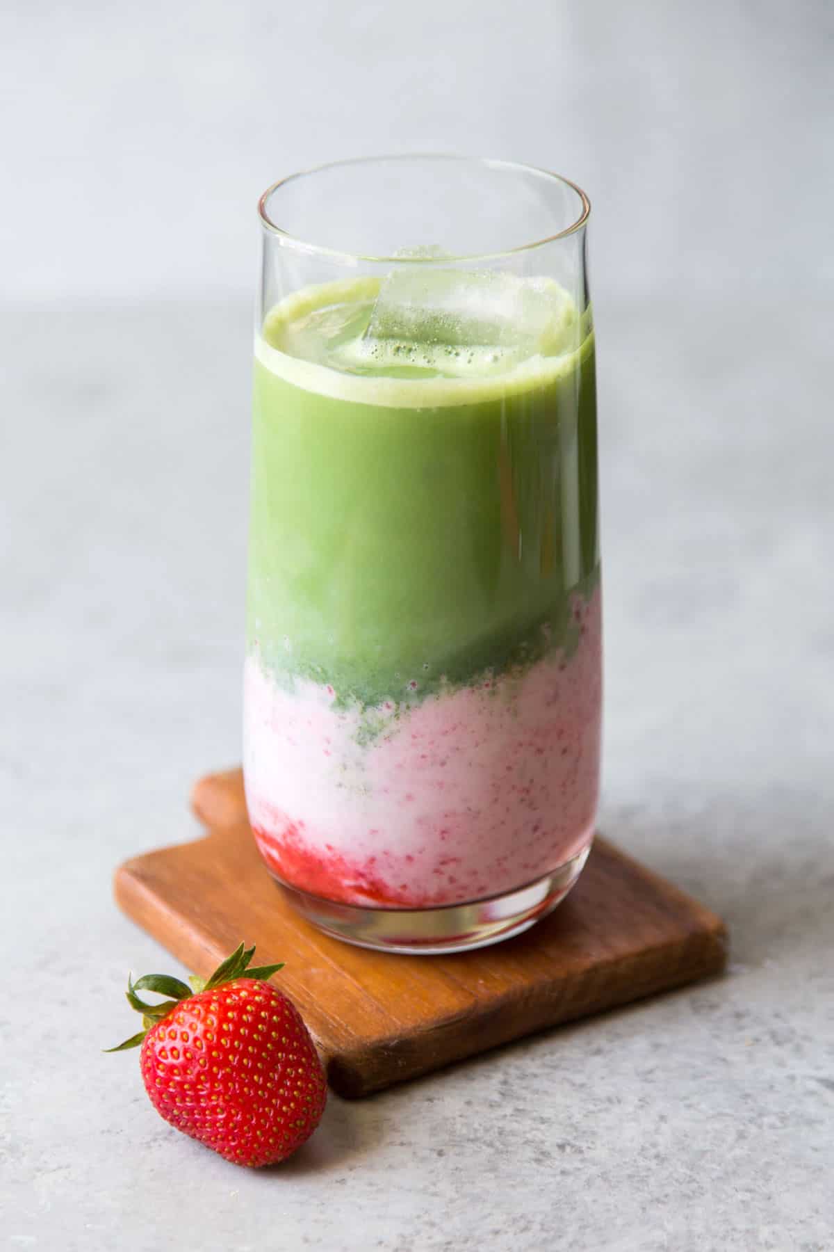 layered drink of strawberry milk and matcha in tall serving glass.