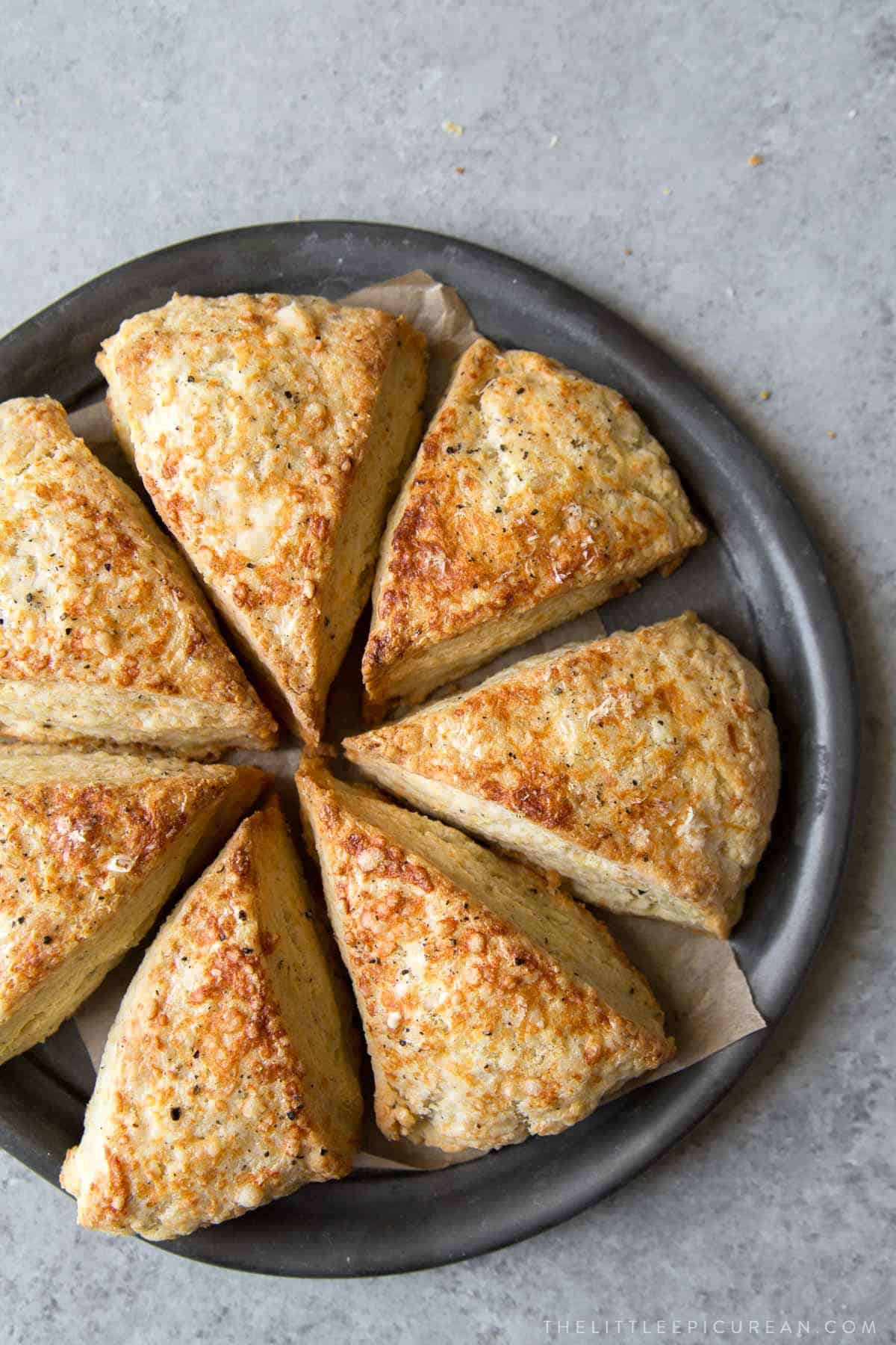 savory cheese scone wedges arranged in a circle on grey plate.
