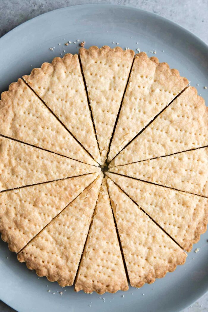 9-inch fluted shortbread round sliced into 12 wedges on blue serving plate.