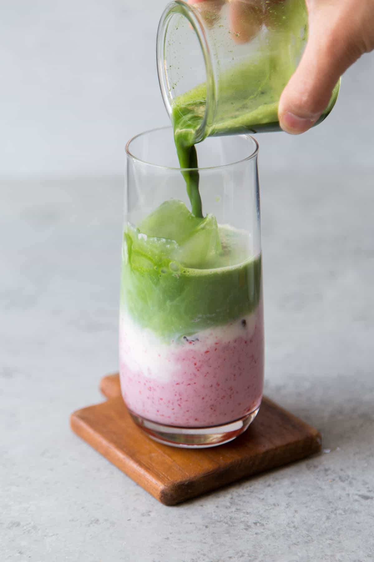 layer prepared matcha over strawberry milk mixture.