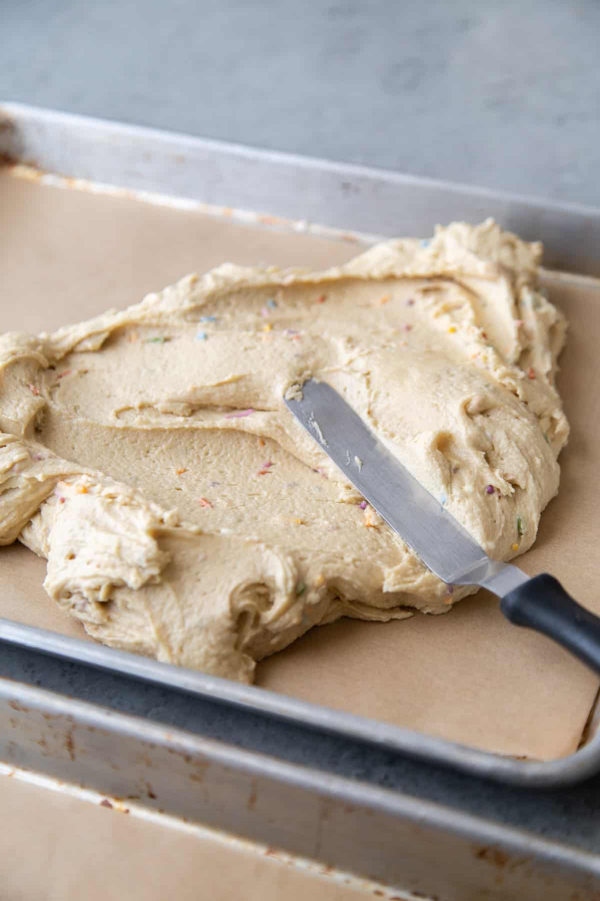 spread sugar cookie dough on prepared sheet tray.