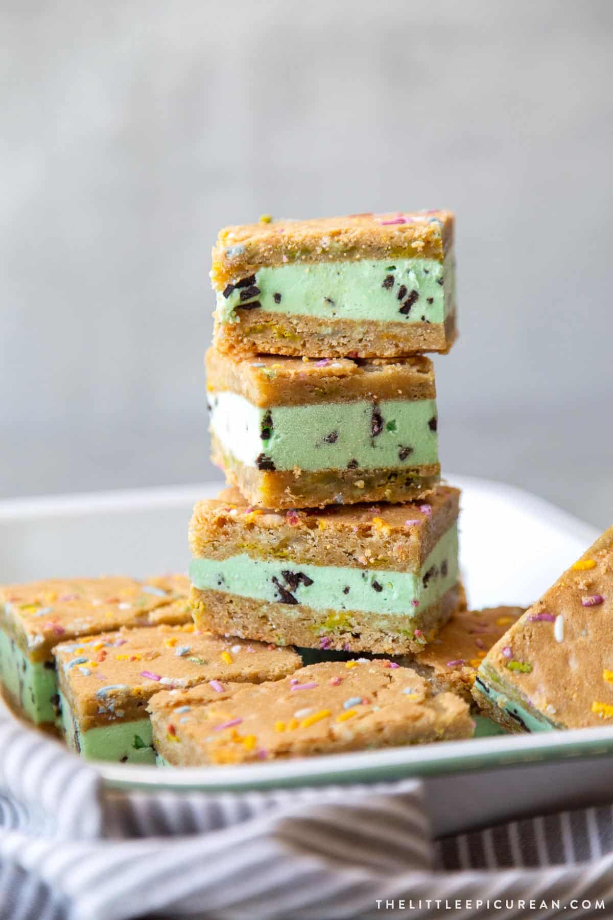 stack of mint chocolate chip ice cream sugar cookie sandwiches on platter.