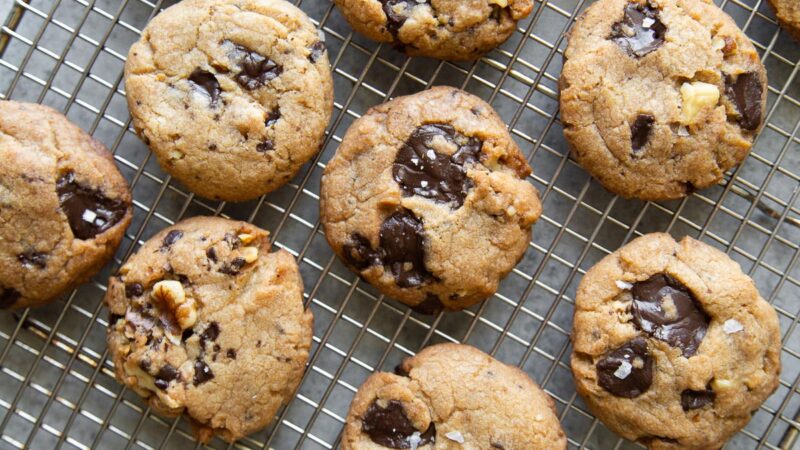 vegan chocolate chip cookies with walnuts cooling on wire rack.