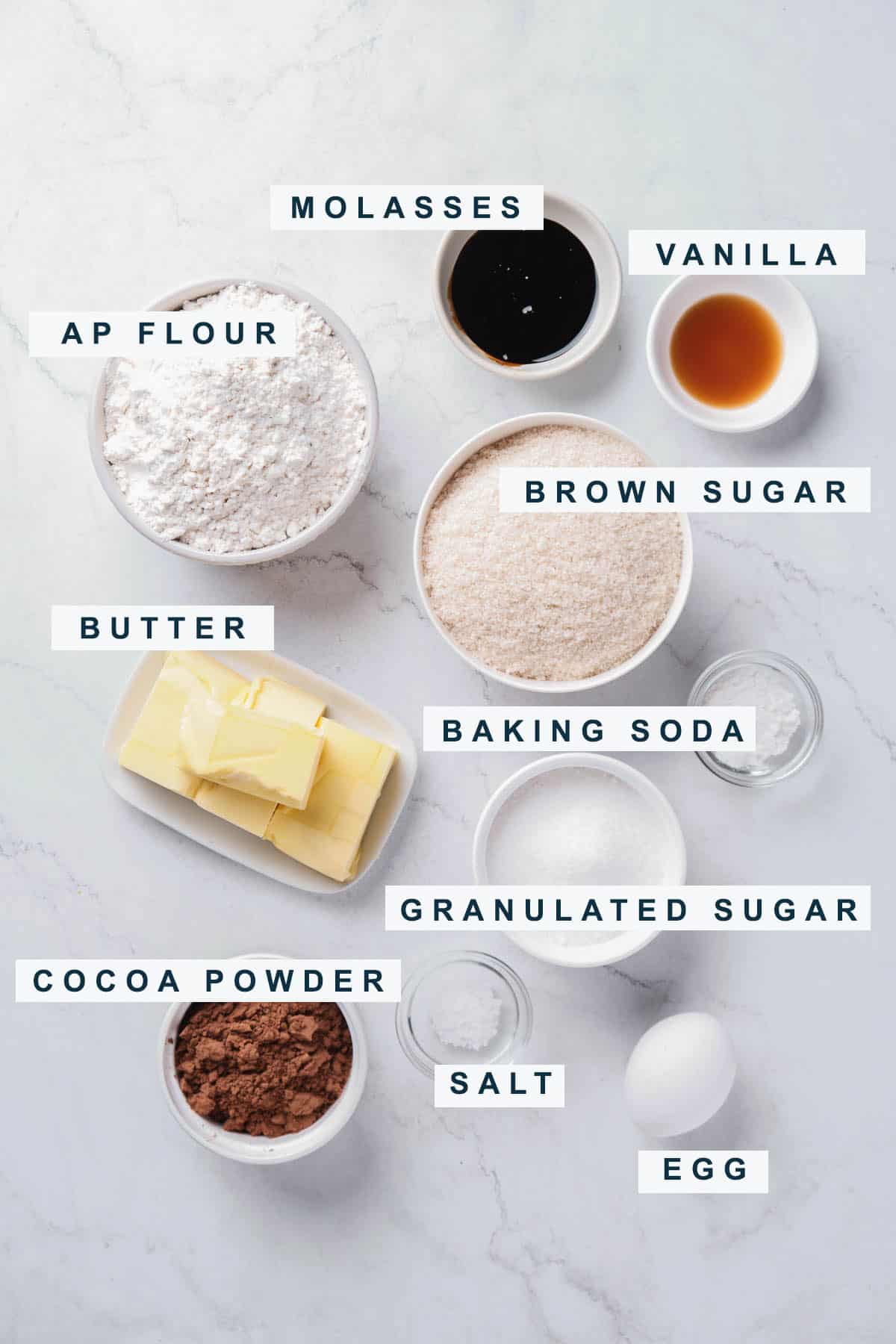 portioned out ingredients for chocolate sugar cookies include cocoa powder, brown sugar, molasses, and butter.