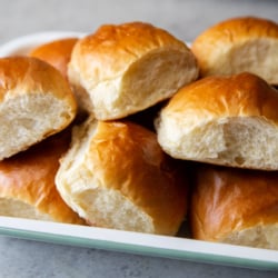 milk bread rolls piled up on serving platter.