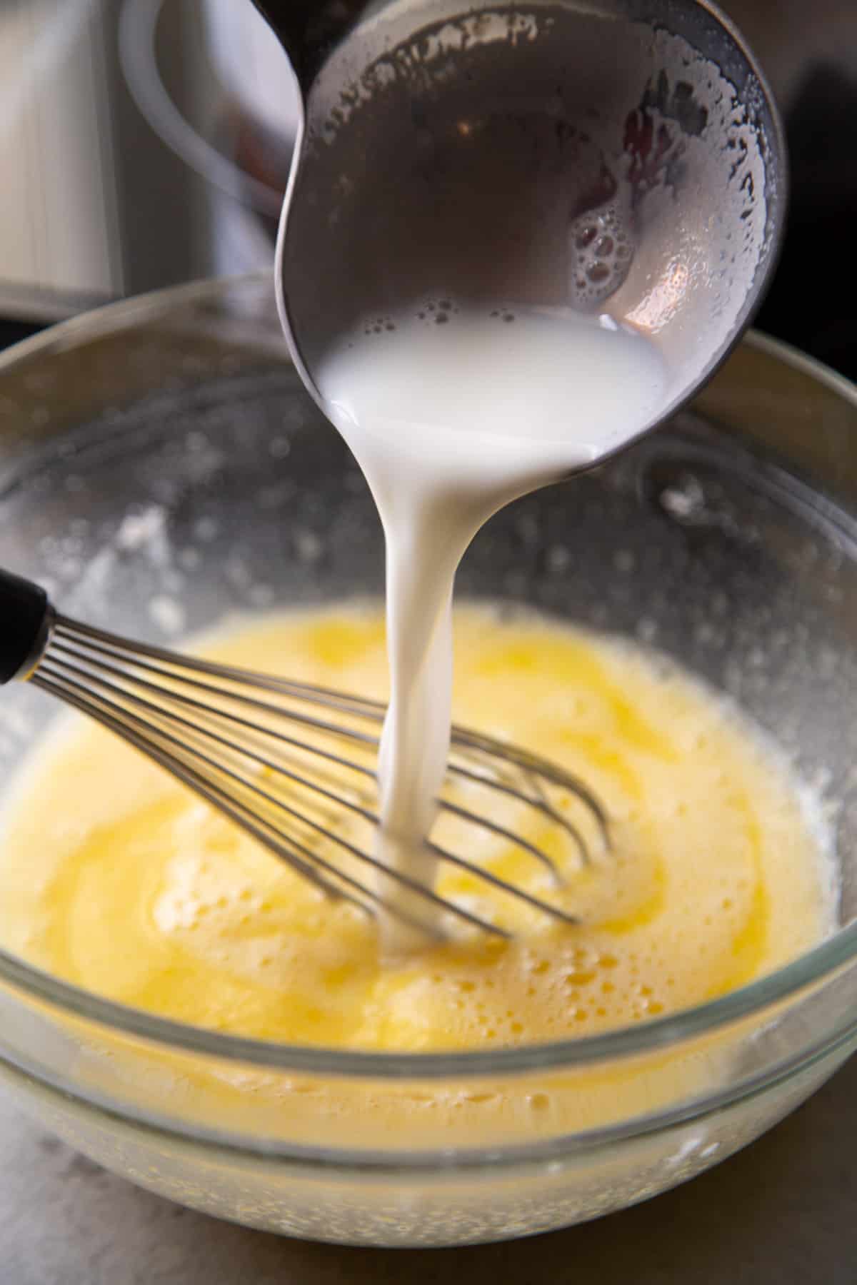 temper eggs by slowing adding hot liquid and quickly whisking.