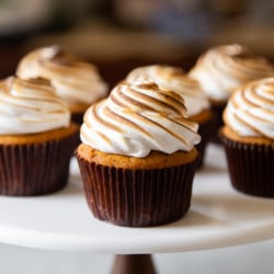 six sweet potato cupcakes with toasted marshmallow meringue frosting on cake stand.